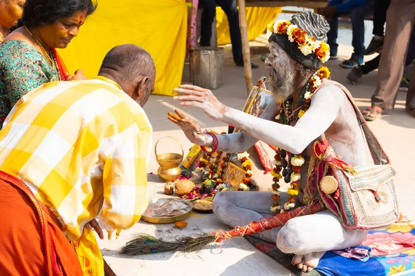 VARANASI, INDIA, MAR 10, 2019 - Unidentified Hindu Sadhu holy man, sits on the ghat near the Ganges river in Varanasi, India — Stock Photo, Image