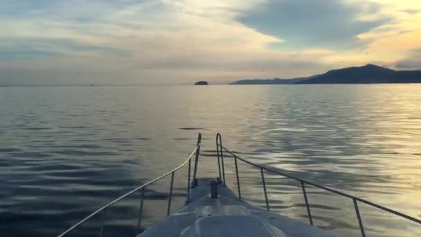 Ein segelndes schnellboot mit wunderschönem sonnenuntergang mit bergen auf bali, indonesien, 4k video — Stockvideo