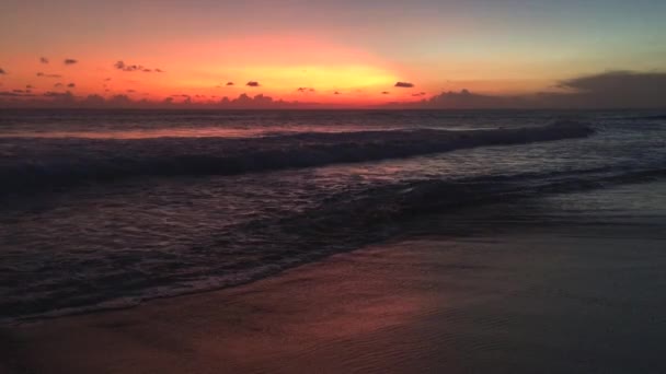 Hermoso paisaje nublado sobre el mar con las olas y la silueta de la gente durante la puesta del sol, Bali, Indonesia, 4k metraje de vídeo — Vídeo de stock