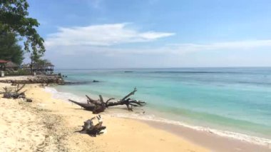 Arka planda mavi gökyüzü ve Lombok adası olan beyaz kumlu sahil, Gili Trawangan, Endonezya, 4k video