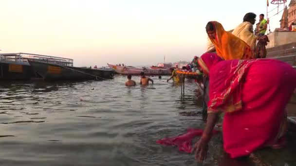 India, Varanasi, Ganga, 15 mar 2019 Los peregrinos hindúes ofrecen oraciones en la orilla del río sagrado Ganges durante el amanecer en Varanasi, video de imágenes 4k — Vídeo de stock