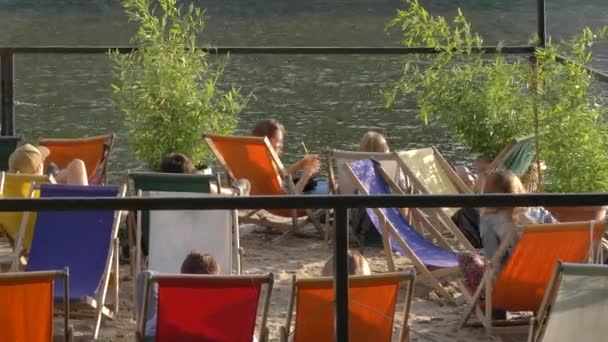 Chaise de plage pour personnes relaxantes près de la rivière — Video