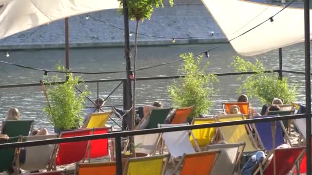 Chaise de plage pour personnes relaxantes près de la rivière — Video