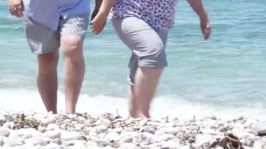 Beyaz kum taşlı plajda berrak Akdeniz'e yakın yürüyen Orta Çağ Çift