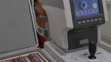Bir göz muayenesi modern autorefractor bilgisayar kontrollü makine kadın hasta closeup göz. Arka planda gözlük ile optometri kliniğinde tıbbi katılım