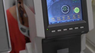 Bir göz muayenesi modern autorefractor bilgisayar kontrollü makine kadın hasta closeup göz. Arka planda gözlük ile optometri kliniğinde tıbbi katılım