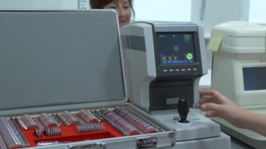 Orta yaşlı kadınların göz muayenesi modern otomatik fraktör bilgisayar kontrollü makine. Optometri kliniğinde arka planda gözlüklerle tıbbi katılım