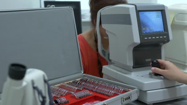 CLoseup oeil mobile sur l'examen à l'écran moderne autoréfracteur machine contrôlée par ordinateur. Assistance médicale à la clinique d'optométrie avec lunettes en arrière-plan — Video