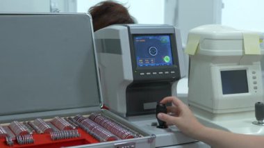 Bir göz muayenesi modern autorefractor bilgisayar kontrollü makine kadın hasta closeup göz. Arka planda gözlük ile optometri kliniğinde tıbbi katılım