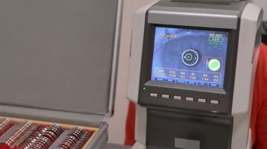 Bir göz muayenesi modern autorefractor bilgisayar kontrollü makine kadın hasta closeup göz. Arka planda gözlük ile optometri kliniğinde tıbbi katılım