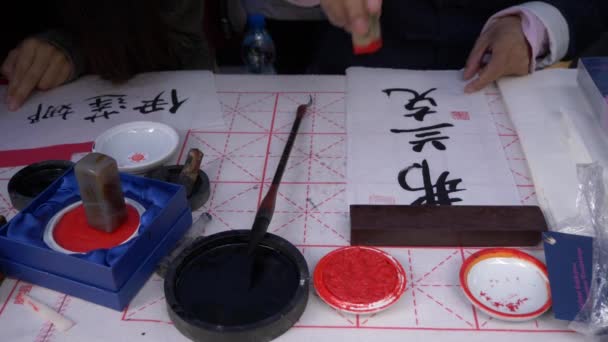 Slow motion, close-up shot of hand using a stamp to write traditional Japanese calligraphy — Stock Video