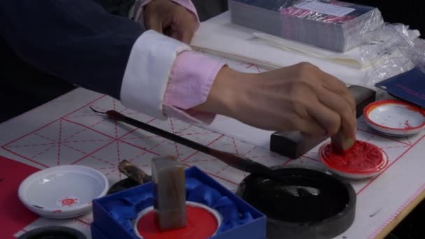 Slow motion, close-up shot of hand using a stamp to write traditional Japanese calligraphy — Stock Video