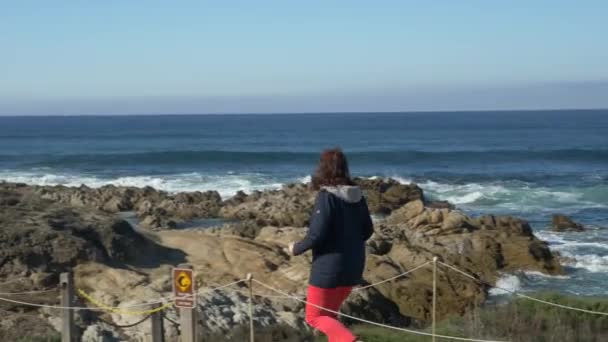 Mature senior women running smiling. Pacific ocean in background — Stock Video