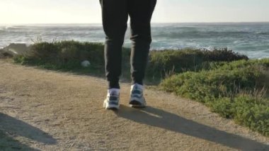 Erkek bacakları yakın. Pasifik sahillerinde antrenman yapmamak güneşli bir günde muhteşem dalgalarla spor yapmak sağlıklı bir vücut.