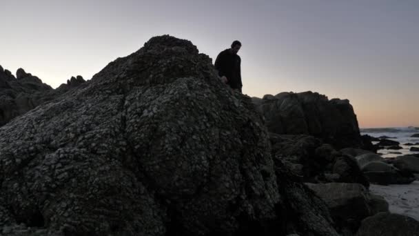 Hombres practicando la técnica de relajación caminando en la costa rocosa del Pacífico — Vídeos de Stock