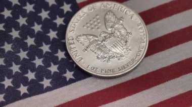 Gümüş dolar ve Amerikan bayrağı nakit para ve bozukluklar. Finans ve yatırım konsepti. Yakın plan çekim. 100 USD 'lik döviz değişimi. ABD 'nin zengin iş ekonomisi