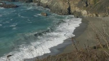 Ağır çekim manzaralı dalgalar ve sahil kamerası Kaliforniya 'nın batı kıyısındaki Big Sur Otoyolu' nda yukarı doğru eğiliyor.