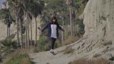Calafia Park San Clemente California 'da yaya yolunda yürüyen aktif kıdemli bir kadın.