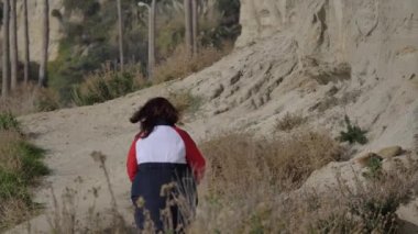 Calafia Park San Clemente California 'da yaya yolunda yürüyen aktif kıdemli kadın. Rüzgarlı bir hava.