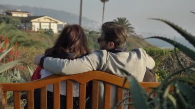 Bankta oturan bir çift Laguna Beach 'te kadınları öpüyor. Harika bir manzara.
