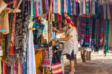 Chiang Rai, Tayland - 09 Ocak 2014: Uzun boyunlu ve yüzük ona bir kadınla bir sayaç İpek eşarp satışı için hazırlanıyor.