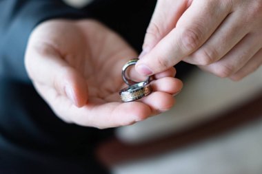 Damat elinde iki sıradışı alyans tutuyor. Bir adamın avucunda damgalı bir yüzük..