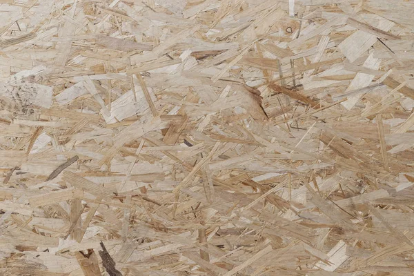 Pressed and glued wood chips. Plywood board Abstract background. Texture of plywood from large wood chips.