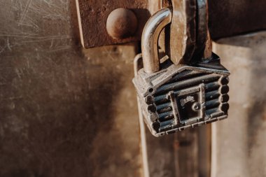 Kulübe şeklinde asma kilit kapalı kapının menteşelerinde asılı duruyor. Metal kapılar.