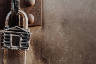 Kulübe şeklinde asma kilit kapalı kapının menteşelerinde asılı duruyor. Metal kapılar.