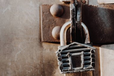 Kulübe şeklinde asma kilit kapalı kapının menteşelerinde asılı duruyor. Metal kapılar.