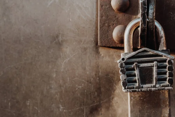 Kulübe şeklinde asma kilit kapalı kapının menteşelerinde asılı duruyor. Metal kapılar.