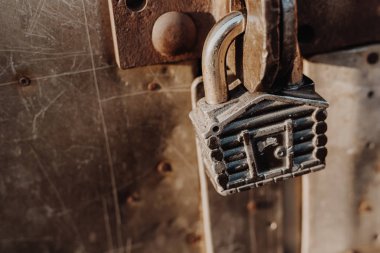 Kulübe şeklinde asma kilit kapalı kapının menteşelerinde asılı duruyor. Metal kapılar.