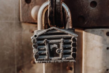 Kulübe şeklinde asma kilit kapalı kapının menteşelerinde asılı duruyor. Metal kapılar.