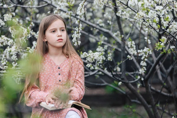 Menina Está Lendo Livro Perto Uma Árvore Florida Jardim — Fotografia de Stock