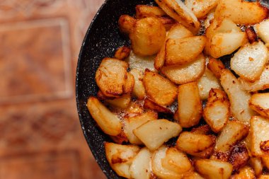 Tavada kızarmış patates parçaları. Zararlı yiyecekler..