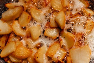 Patates parçaları kızgın yağda kızartılır. Abur cubur pişirirken çekilmiş yakın çekim fotoğrafı..