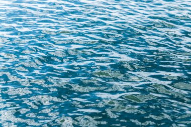 Suda küçük dalgalar. Dalgalanmalar. Duvar kağıdı için soyut arkaplan.