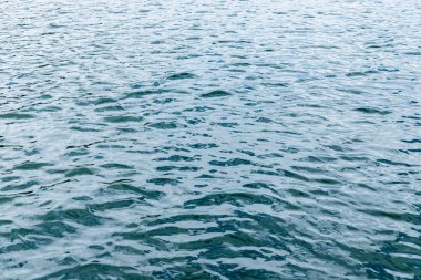 Suda küçük dalgalar. Dalgalanmalar. Duvar kağıdı için soyut arkaplan.