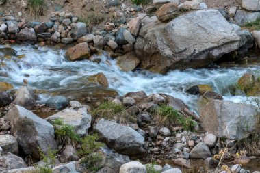 Taşların arasından akan bir dağ deresi..