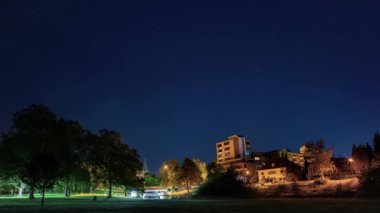 Yıldızlı bir gece gökyüzünün bir şehrin üzerine düşüşü. Paderborn gecesi.