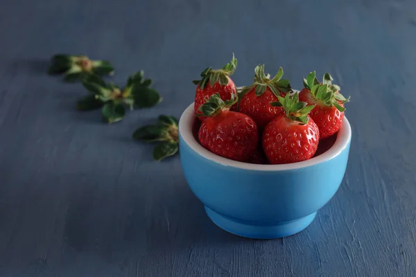 Mavi bir tabak içinde taze çilek