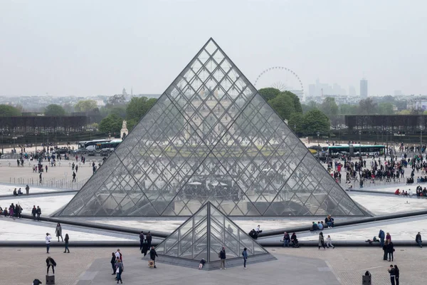 Louvre piramitleri müzepenceresinden hafif bir sis görünümünde Paris'in arka planında yağmurlu bir günde
