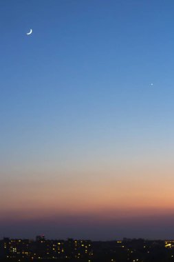 şehrin bokeh ışıkları üzerinde hilal ile mavi günbatımı gökyüzü