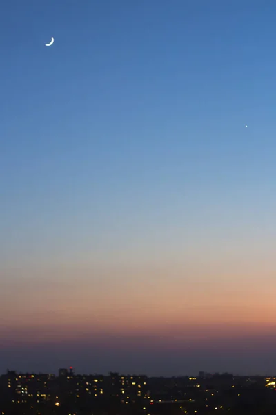 şehrin bokeh ışıkları üzerinde hilal ile mavi günbatımı gökyüzü