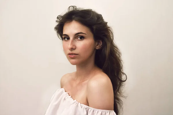 Kameraya bakan çiller ile genç güzel kadının fotoğraf portresi kadar kapatın. Gri arka planda oldukça doğal bir yüz. Saç bakım simgesi. Yeni Mona Lisa