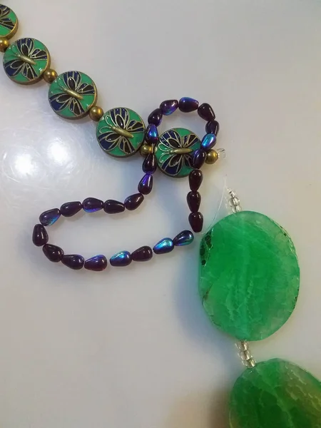 A sample of some blue and green beads, focal piece and other pieces