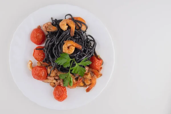 Black spaghetti Nero with seafood and cherry tomatoes with green — ストック写真