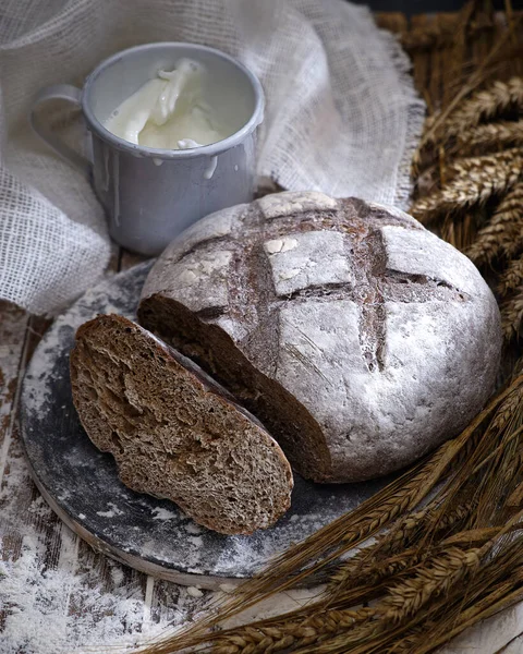 Pane Rotondo Nero Una Coppa Metallo Con Latte Spighe Grano — Foto Stock