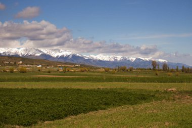 Issyk-Kul gölü yakınlarındaki Grigorievka köyünden Kırgızistan'ın dağ manzarası