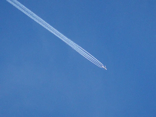 Repülő repülőgép ont az égen a teljes kipufogórendszer háttérben képzőművészet — Stock Fotó